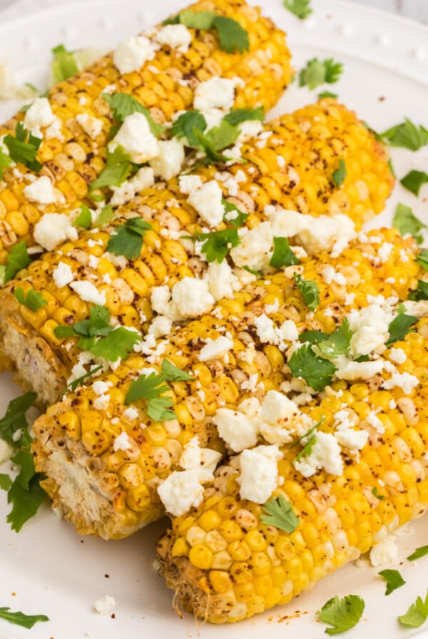 Close up of air fryer Mexican street corn on a white plate ready to serve.