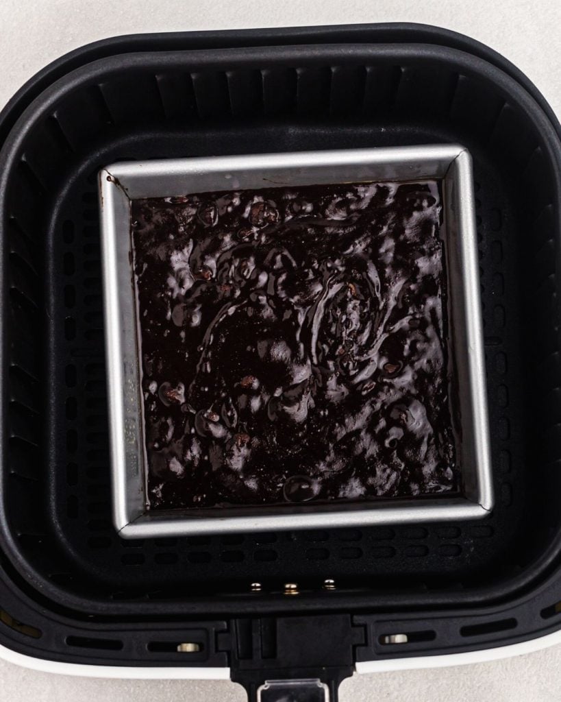 Square baking  pan in an air fryer basket before being cooked. 