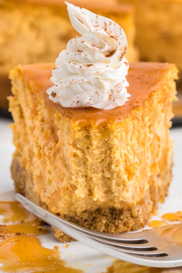 Air Fryer pumpkin cheesecake slice on a white plate with a bite missing.