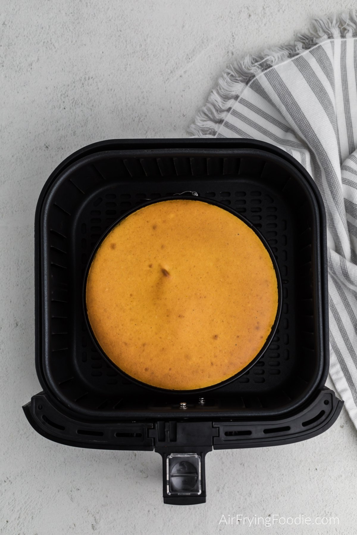 Fully cooked pumpkin cheesecake in the air fryer basket
