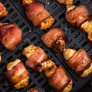 air fried bacon wrapped chicken bites in the basket of the air fryer.