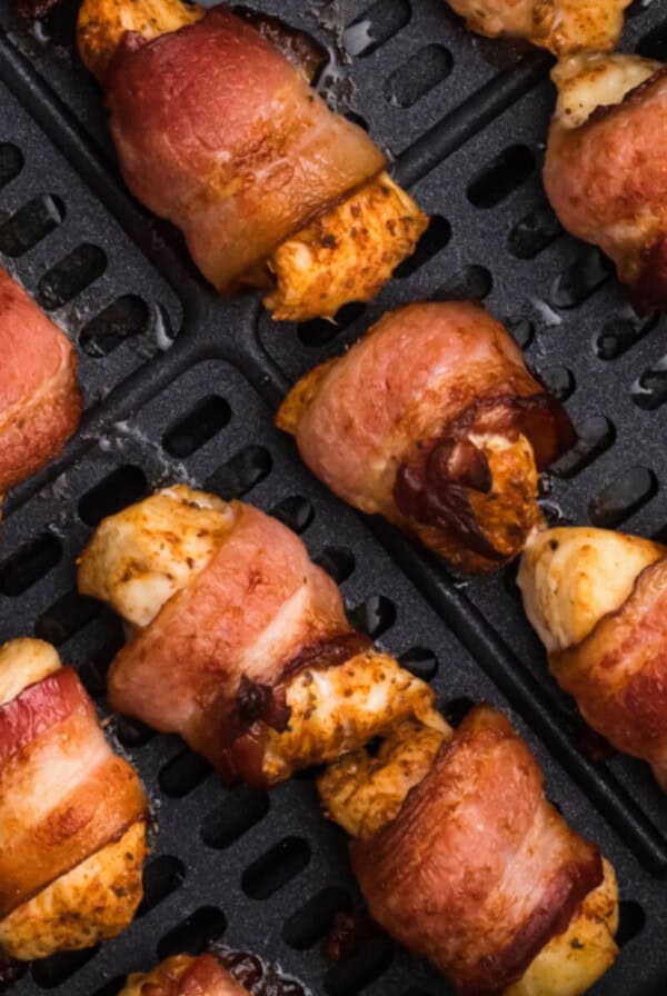 air fried bacon wrapped chicken bites in the basket of the air fryer.