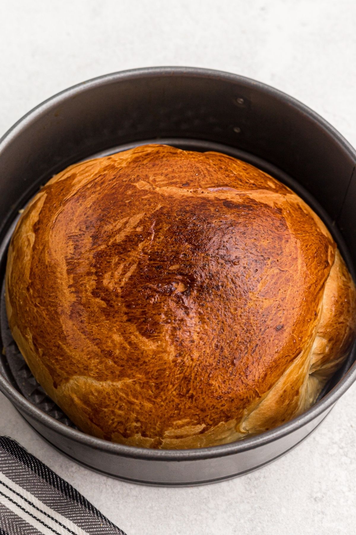 Golden loaf of air fryer bread after being cooked in the spring form pan