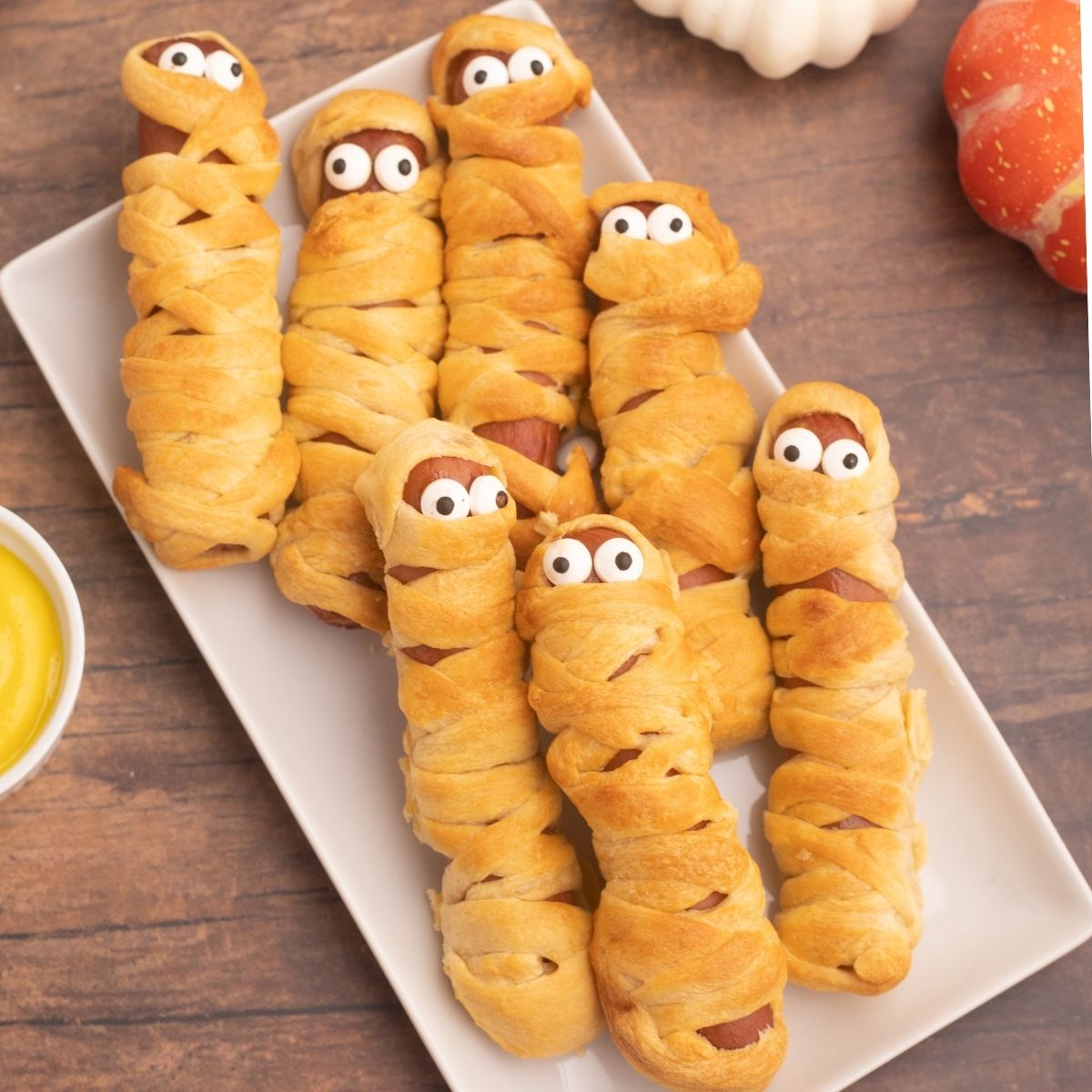 Golden crusted and wrapped hot dogs, to look like mummies with candy eyes