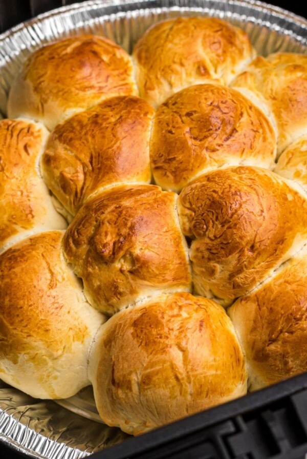 Close up photo of golden rolls in the air fryer basket.