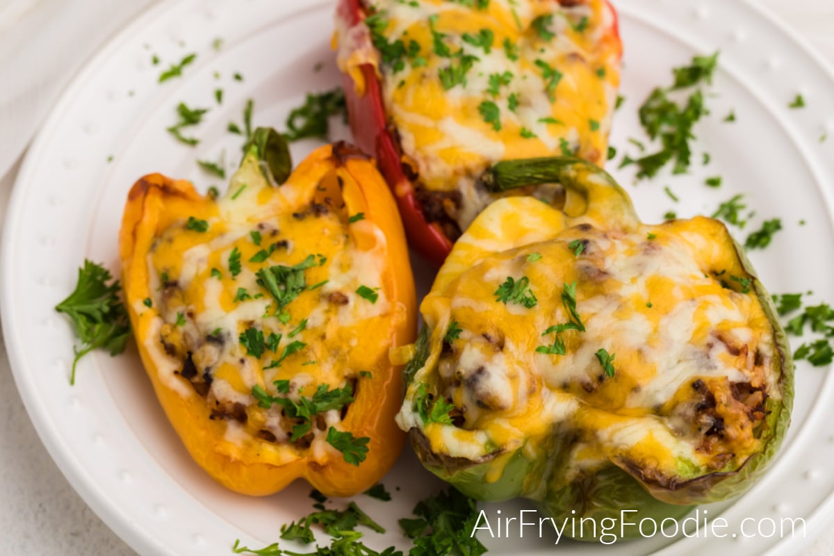 Stuffed bell peppers made in the air fryer on a white plate and ready to serve. 