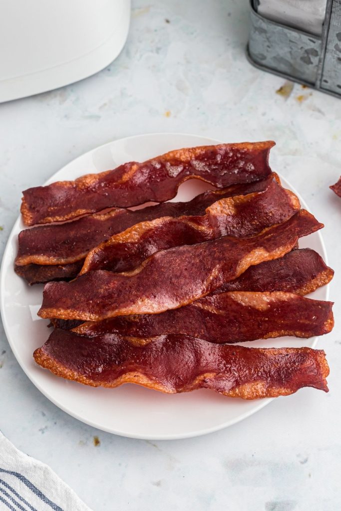 Crispy sizzling turkey bacon cooked and on a white plate
