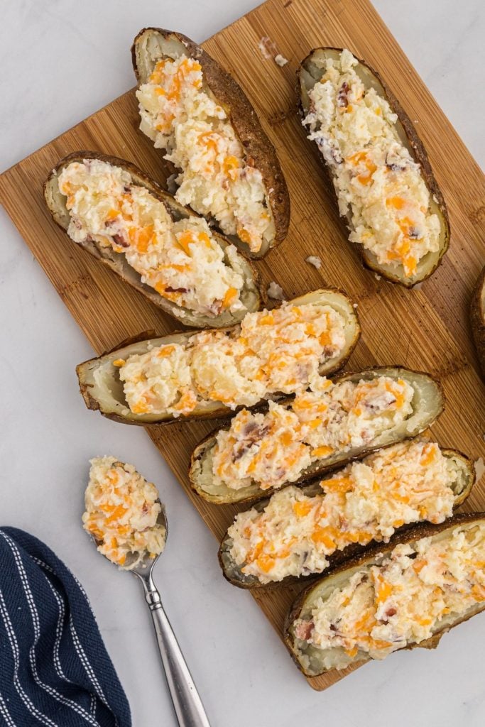 Stuffing potato skins with mixed filling ingredients. 