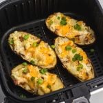 Close up photo of twice baked potatoes after being cooked in the air fryer basket