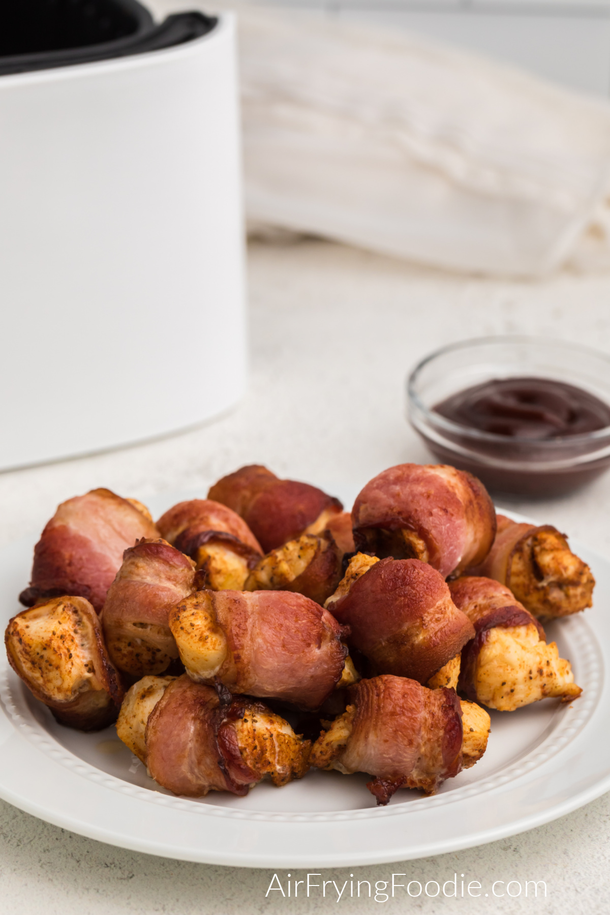 Bacon wrapped chicken bites on a white plate ready to be served. 