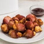 Air Fryer Bacon Wrapped Chicken Bites on a white plate ready to be served.