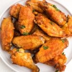 Crispy Air Fryer chicken wings on a white plate ready to serve.