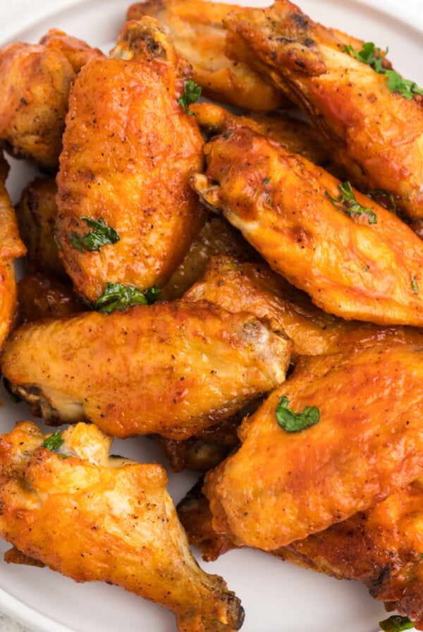 Crispy Air Fryer chicken wings on a white plate ready to serve.