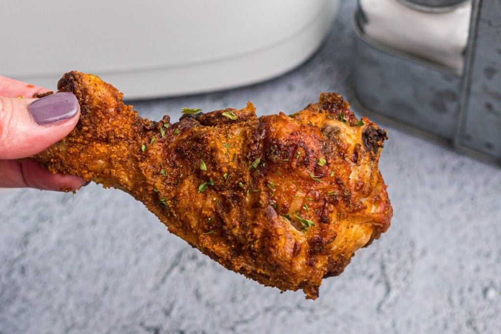 Close up juicy and crispy chicken drumstick with seasonings.