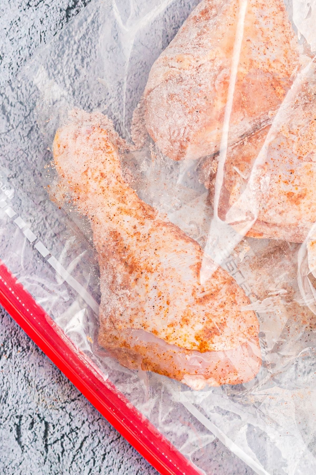 Close up photo showing drumstick in a ziploc bag, shaken with seasonings.