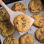 Chocolate Chip cookie on a spatula over the air fryer basket