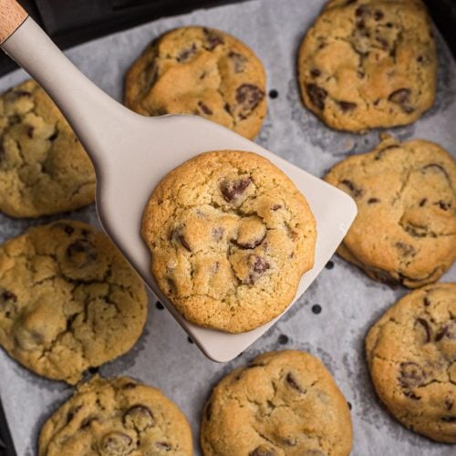 Chocolate Chip cookie on a spatula over the air fryer basket