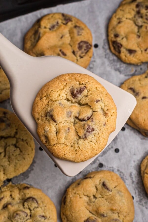 Chocolate Chip cookie on a spatula over the air fryer basket