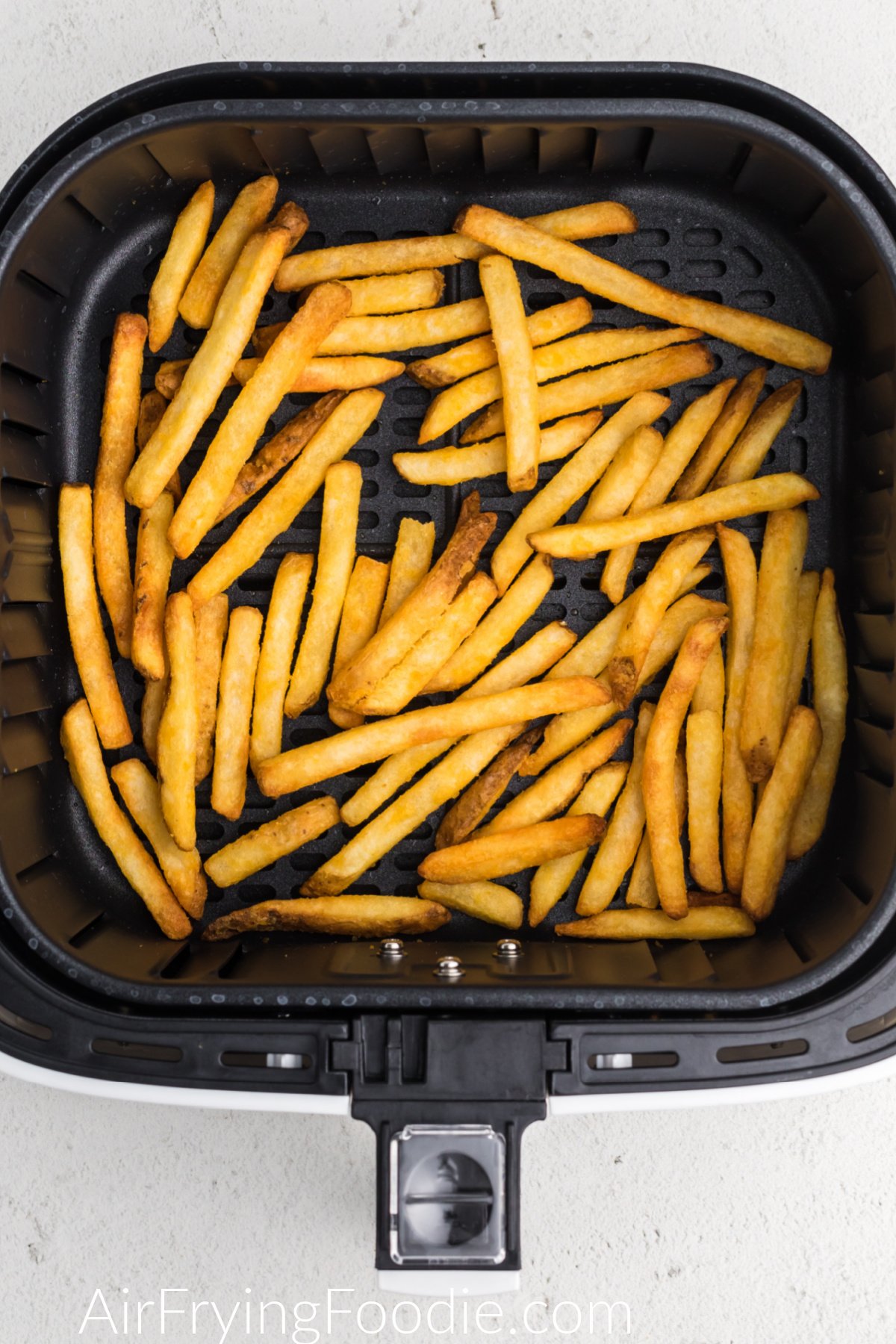 french fries fully cooked from frozen in the air fryer basket.
