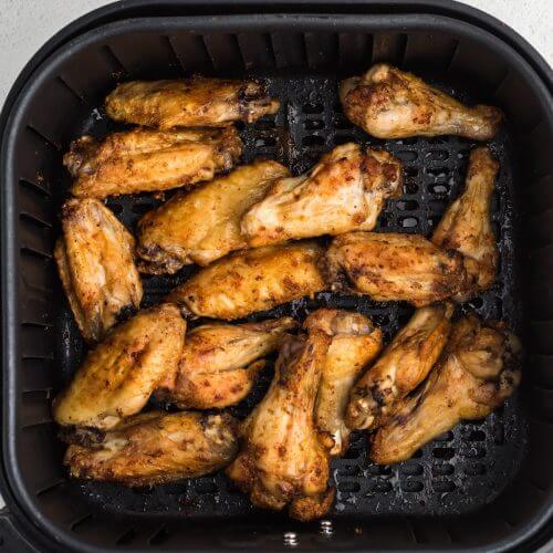 Chicken wings in the air fryer basket.