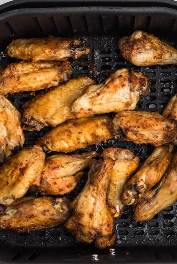 Chicken wings in the air fryer basket.