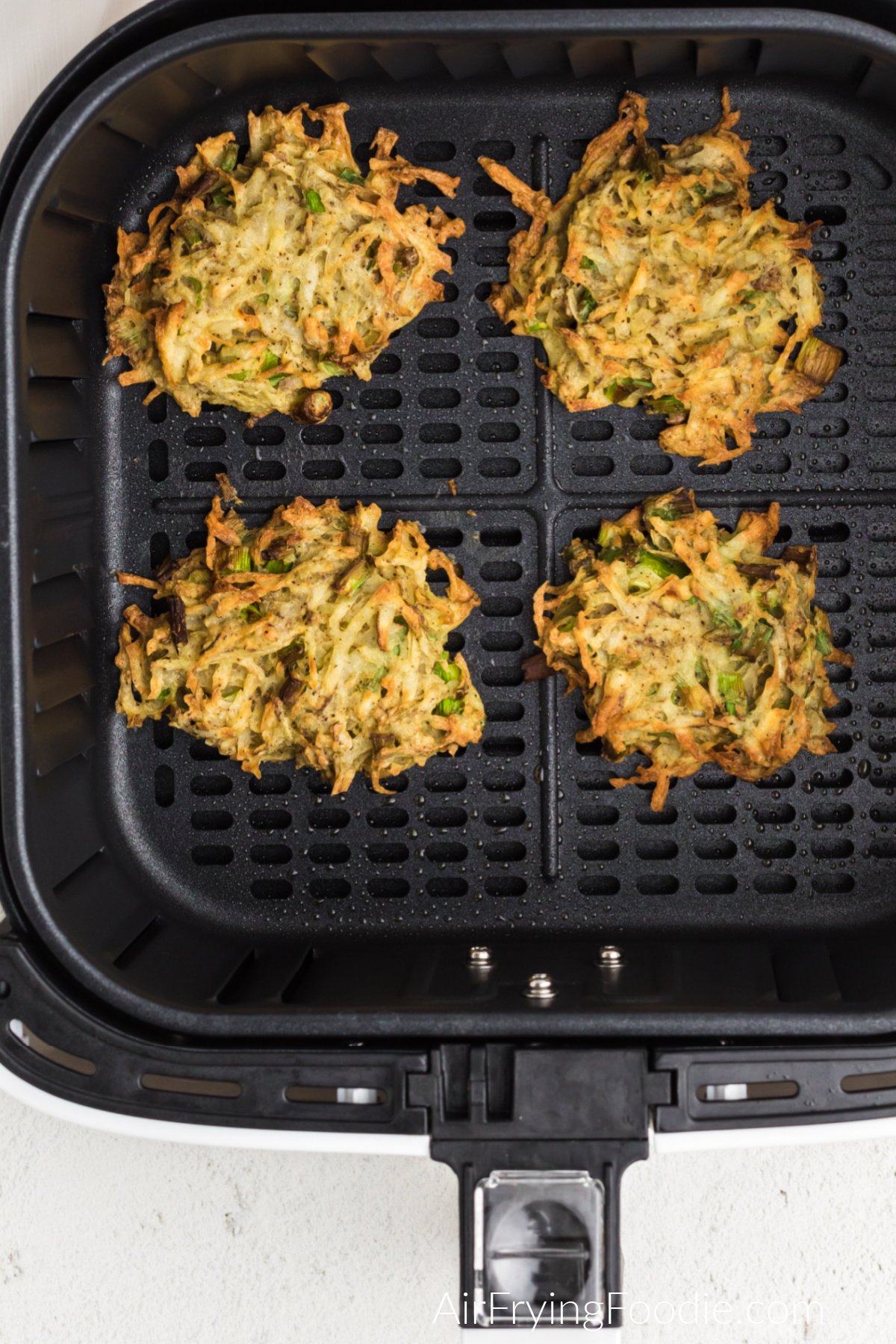 Latkes in the air fryer basket ready to serve.