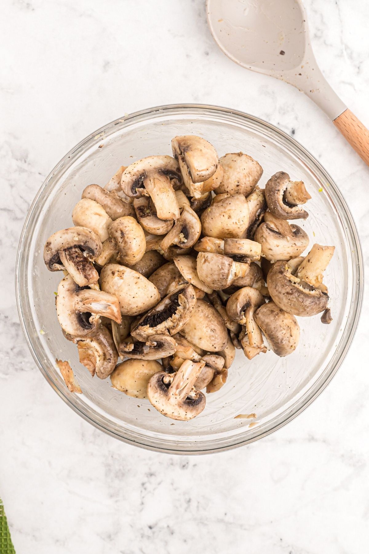 Glass bowl filled with mushrooms tossed with butter and seasonings
