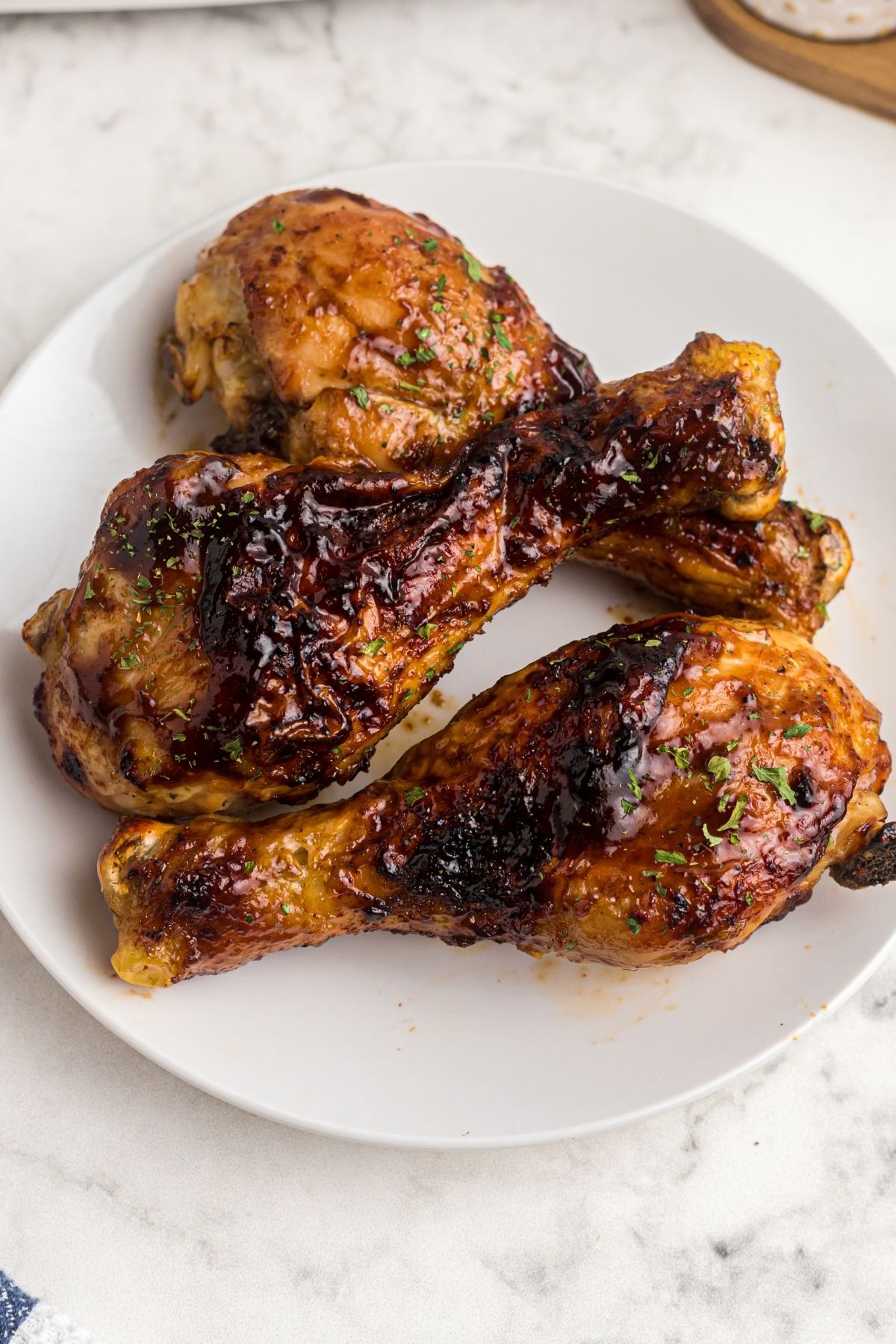 Air-fried BBQ chicken on a white plate garnished with parsley.