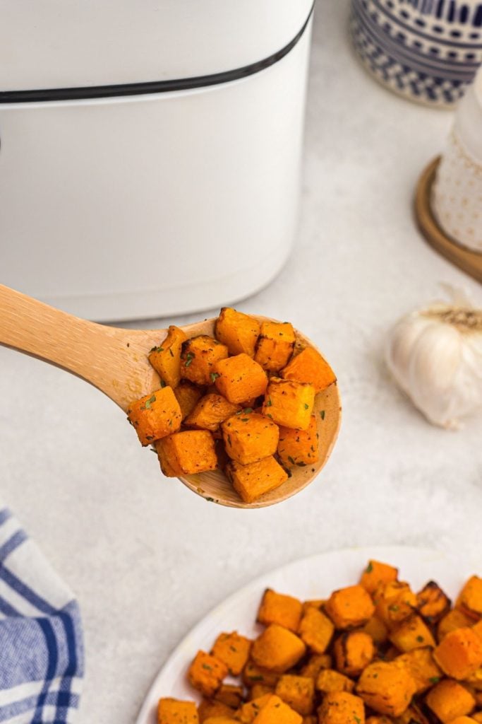 Spoonful of butternut squash in front of the air fryer