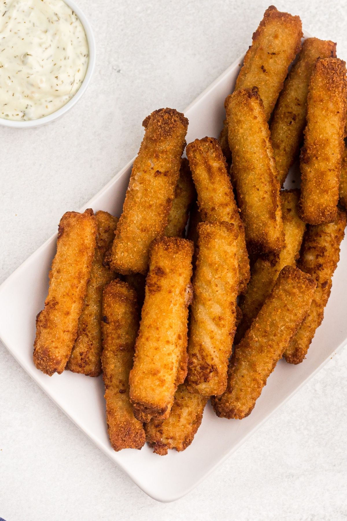 air fryer fish sticks on a white plate.