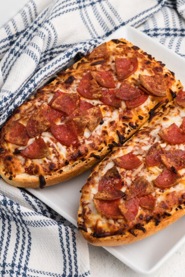 french bread pizza made in the air fryer and served on a white plate.