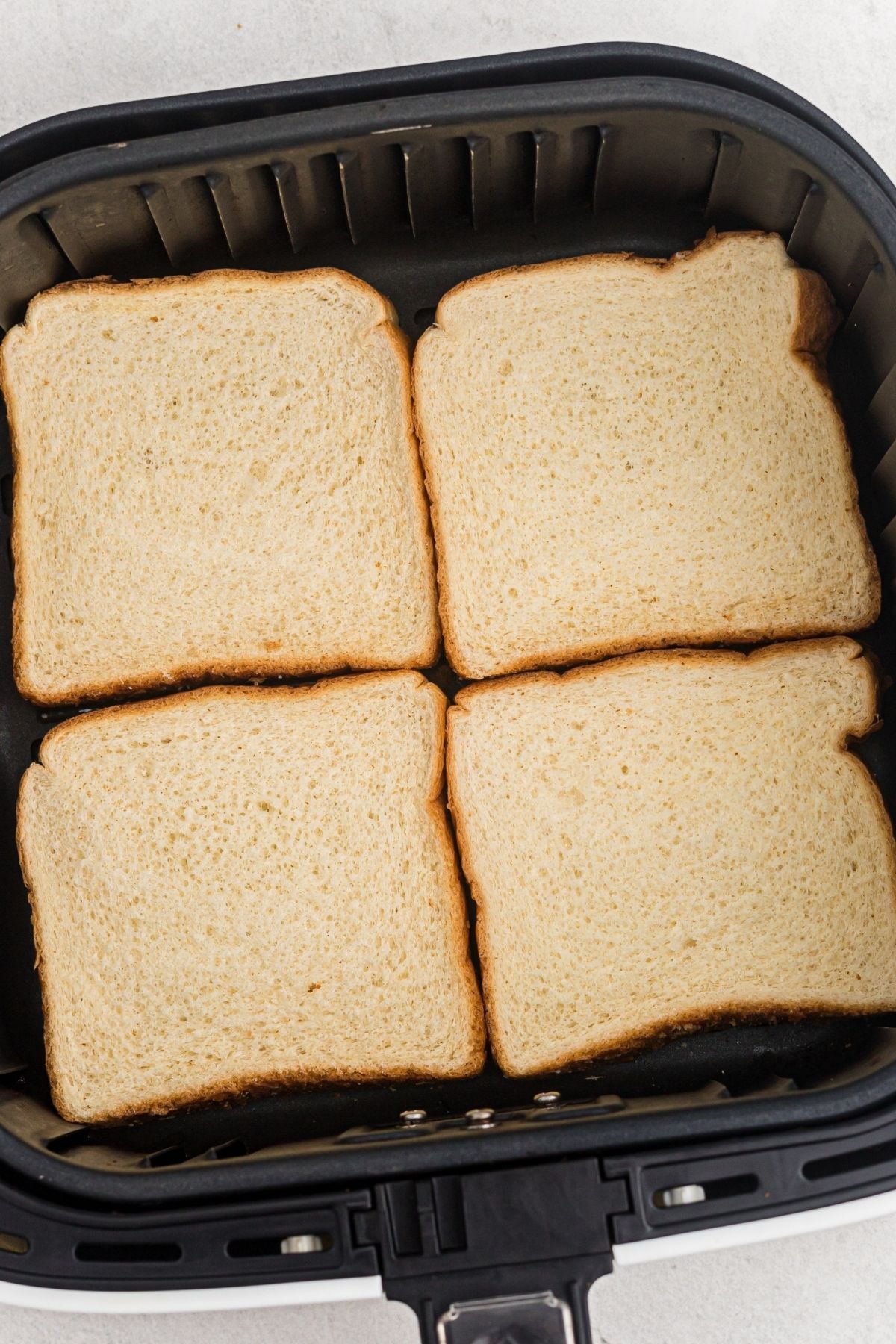 four slices of bread in the air fryer basket before being cooked