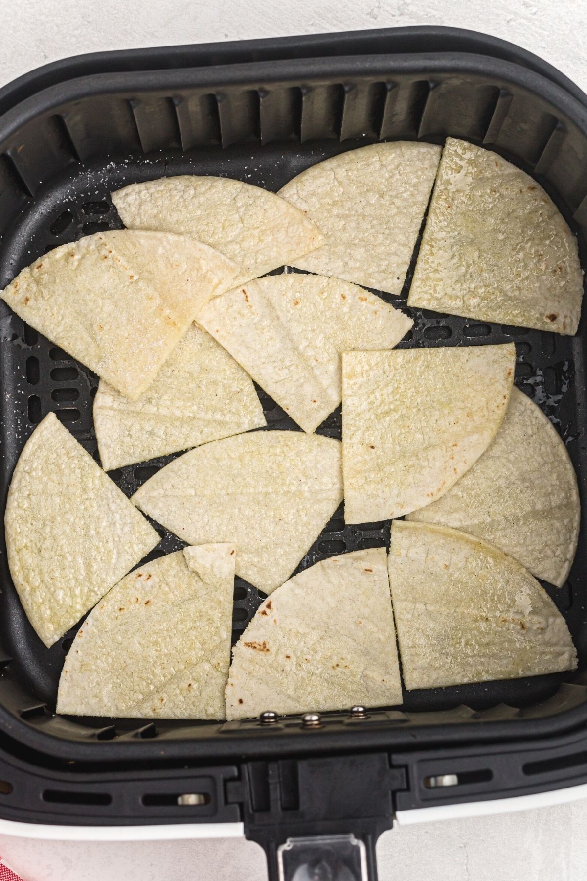 lightly oil and salted slices of tortillas placed in the air fryer basket.