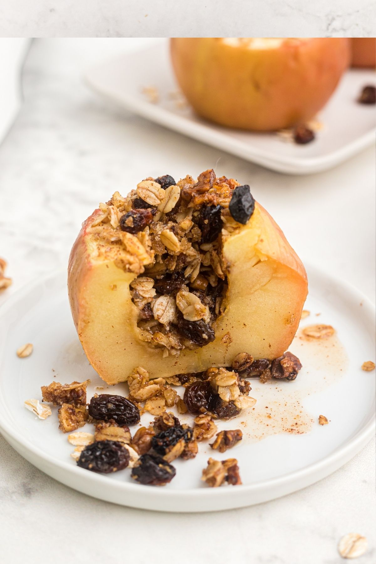 Baked apple sliced in half showing the oats and cranberries stuffed in the core. 