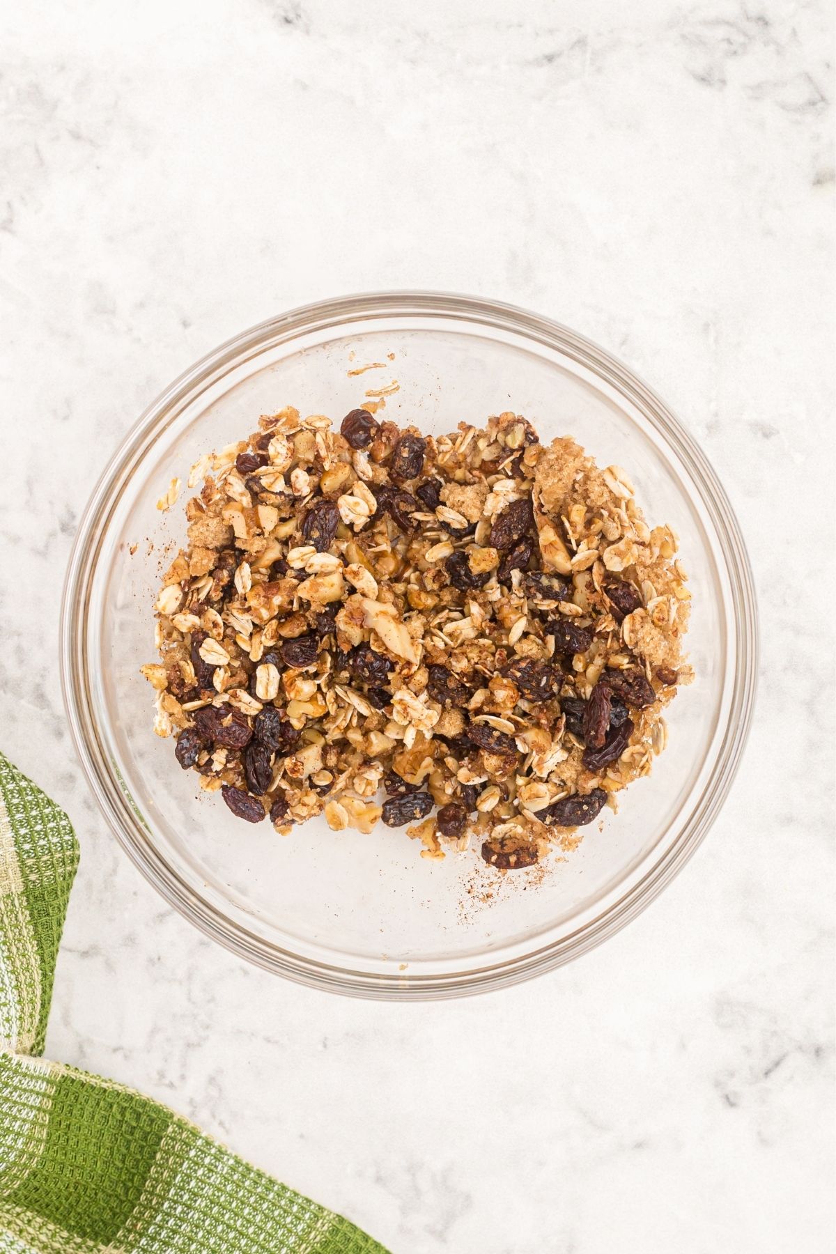 Oats mixture with nuts, raisins and brown sugar in a clear glass bowl