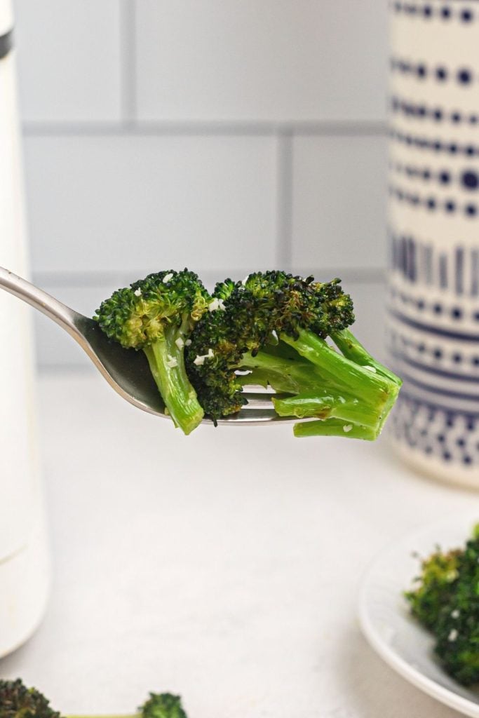 Green juicy cooked broccoli on a silver fork