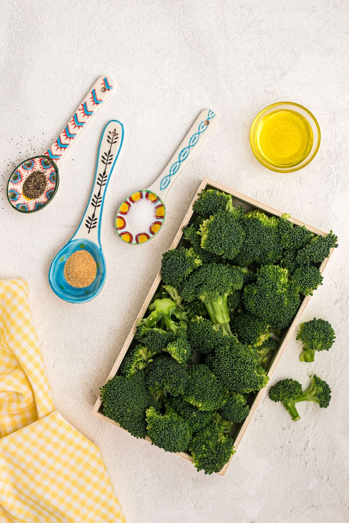 Ingredients needed to make broccoli in the air fryer on a table.
