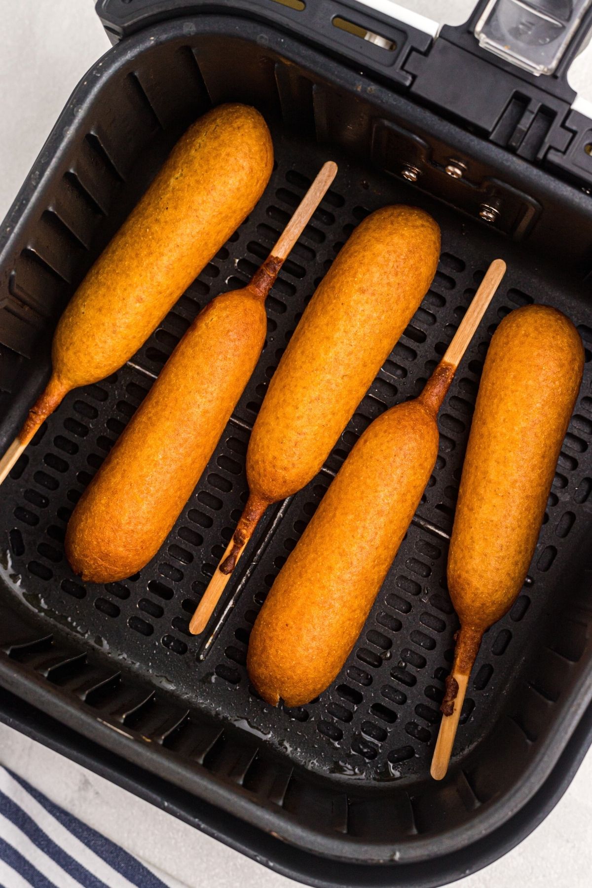 Golden cooked Corn Dogs in the Air Fryer Basket