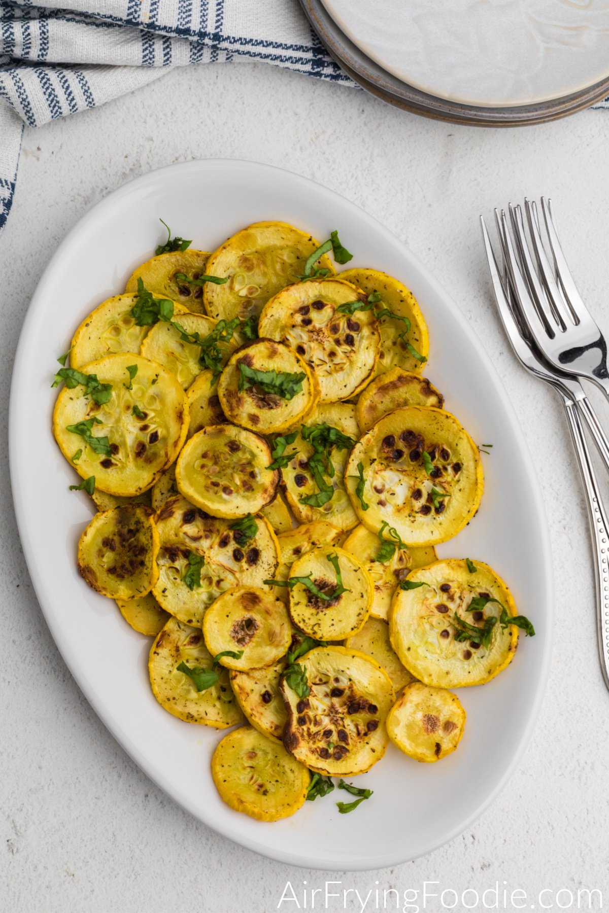 Yellow air fryer squash on a serving plate. 