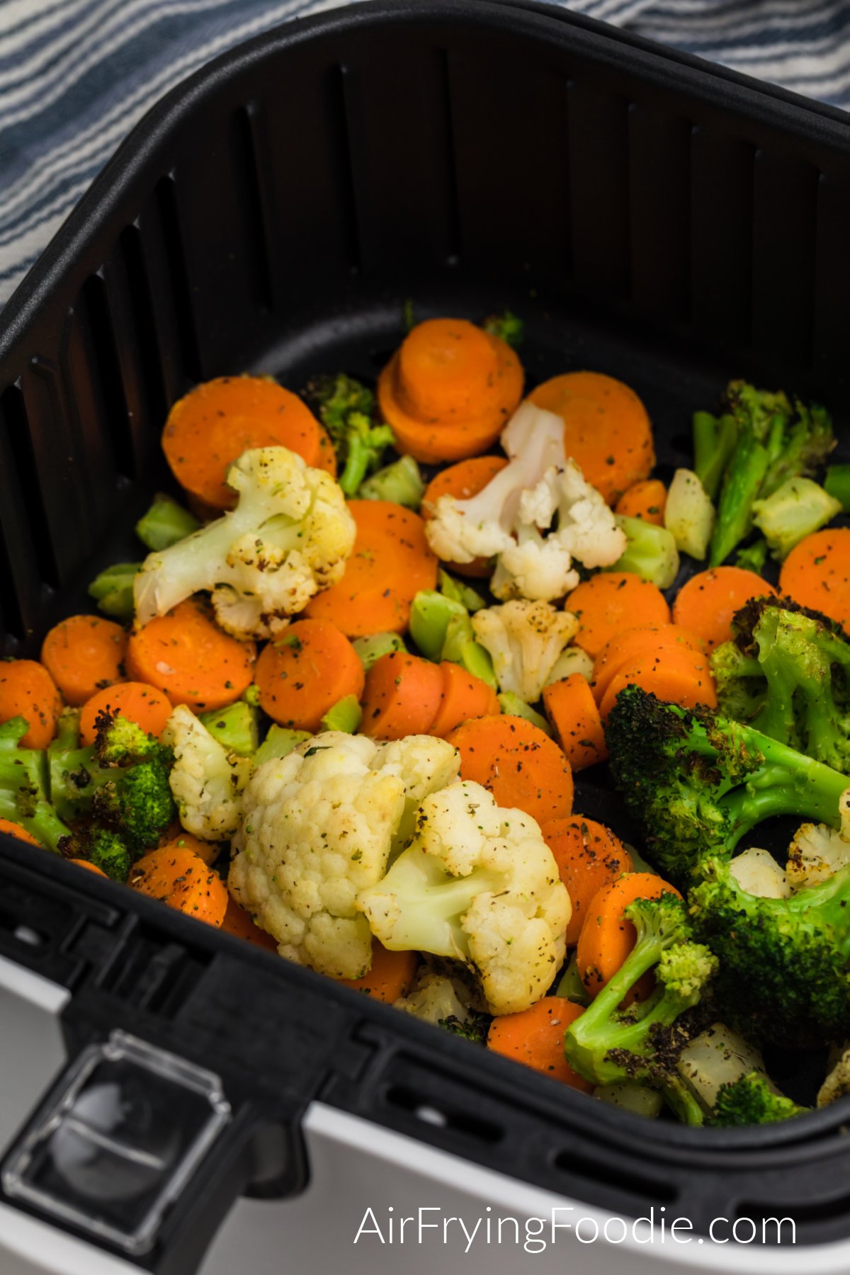 Cooked frozen vegetables in the air fryer basket ready to serve. 