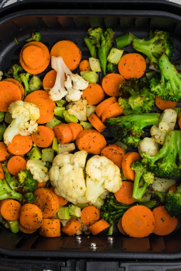 Fully cooked frozen veggies in air fryer basket ready to serve.