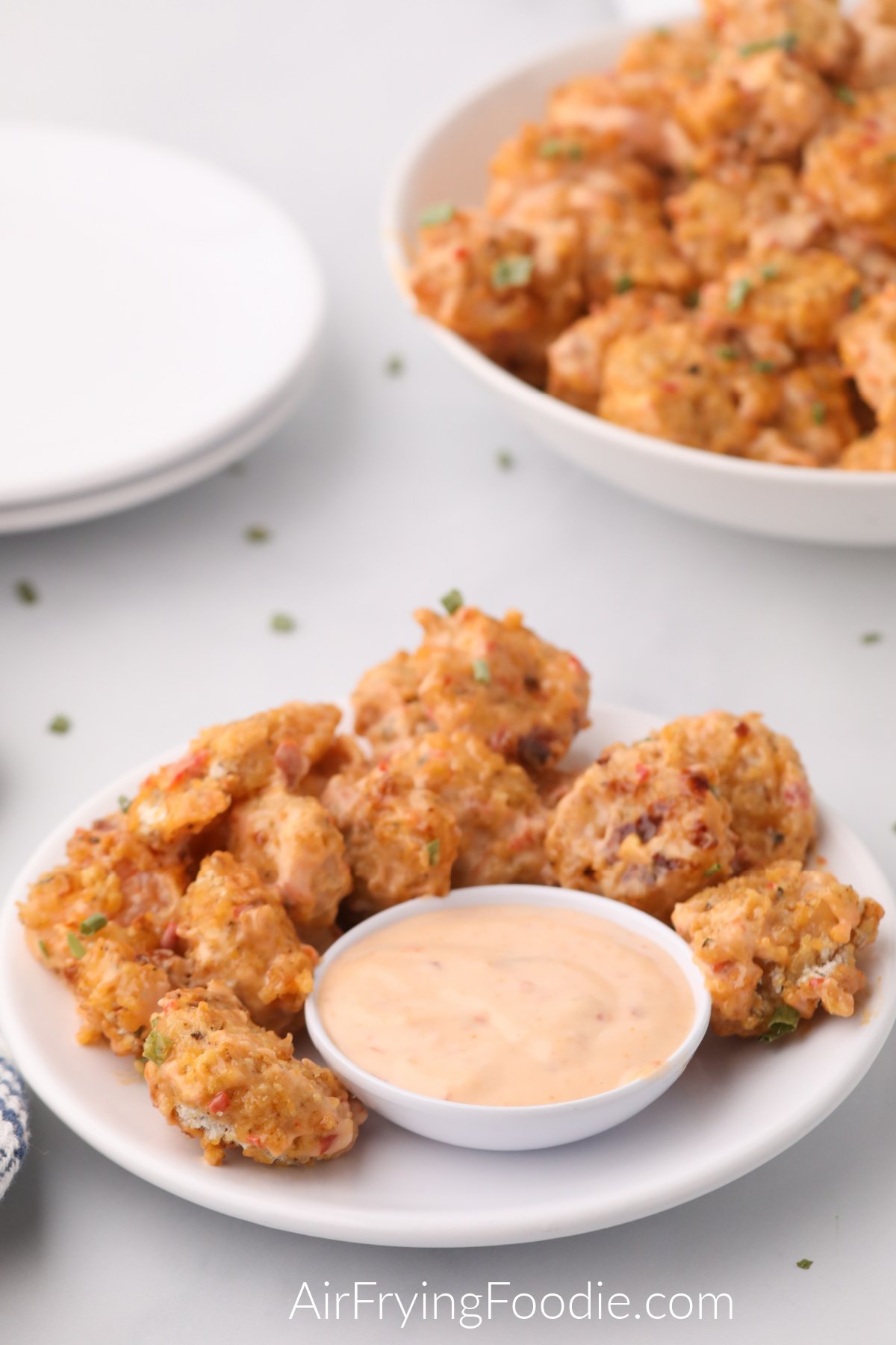 Bang bang shrimp served on plates and with a side of dipping sauce. 