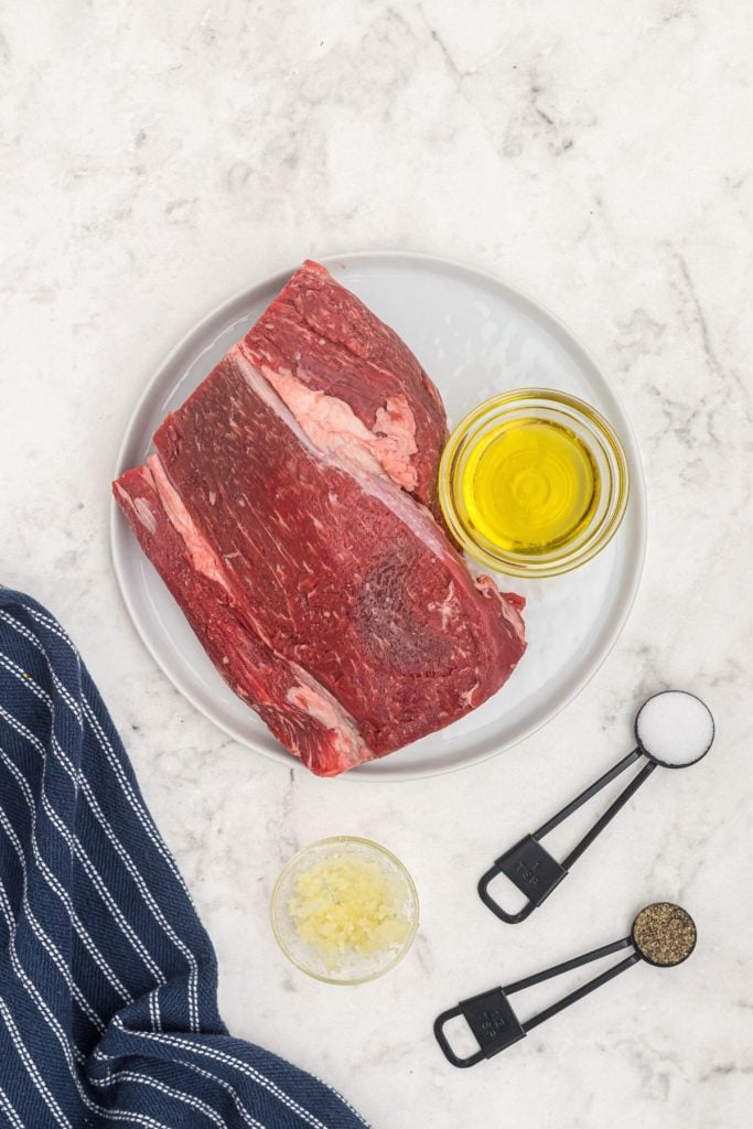 Ingredients measured out to season beef tenderloin, salt, pepper, garlic, olive oil