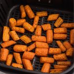Air fried carrots in the basket after being seasoned and cooked, then garnished with parsley