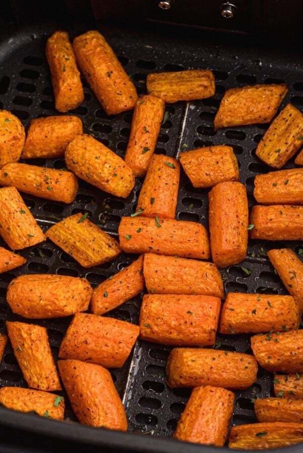 Air fried carrots in the basket after being seasoned and cooked, then garnished with parsley