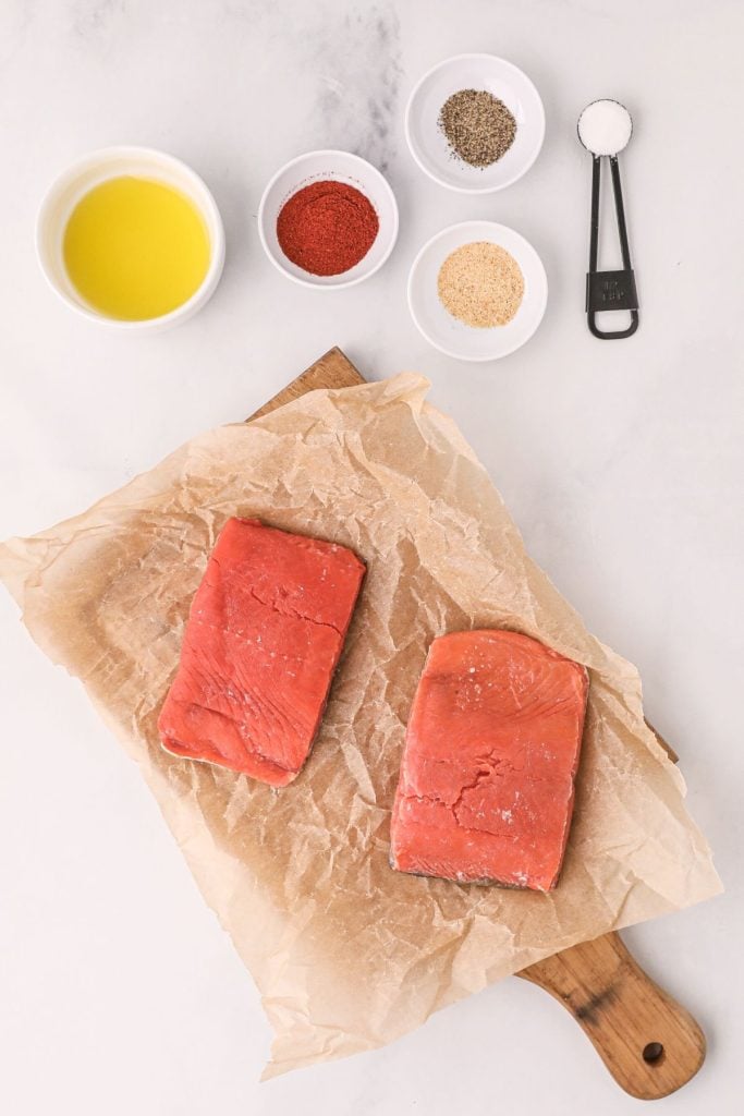 Ingredients to make salmon with seasonings measured on the white table