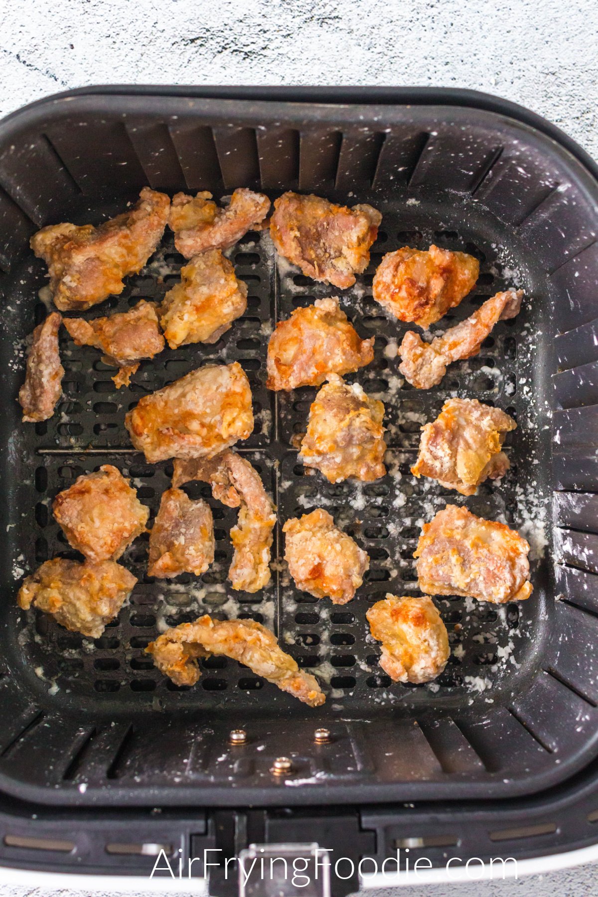 Cooked Sesame Chicken in the basket of the air fryer.
