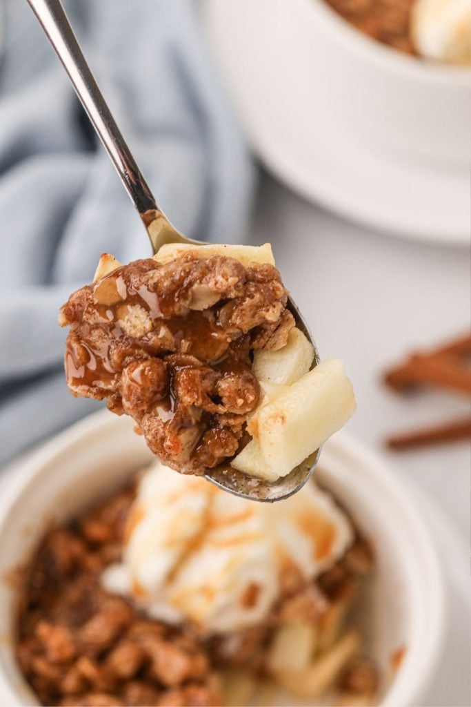 Spoonful bite of apple crisp on a spoon showing apples and oat mixture 