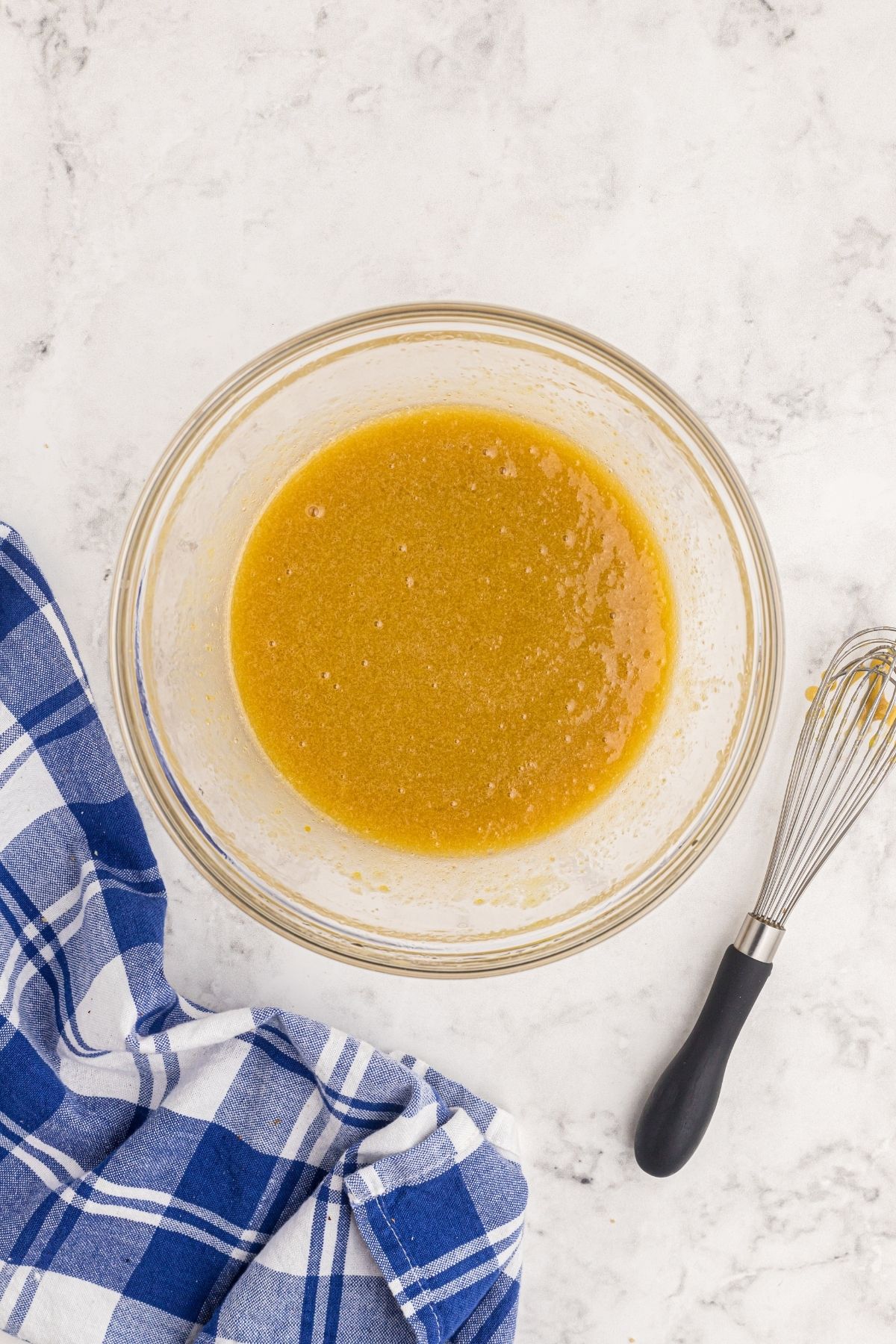 Orange juice, oil and other cake ingredients mixed together in a clear bowl