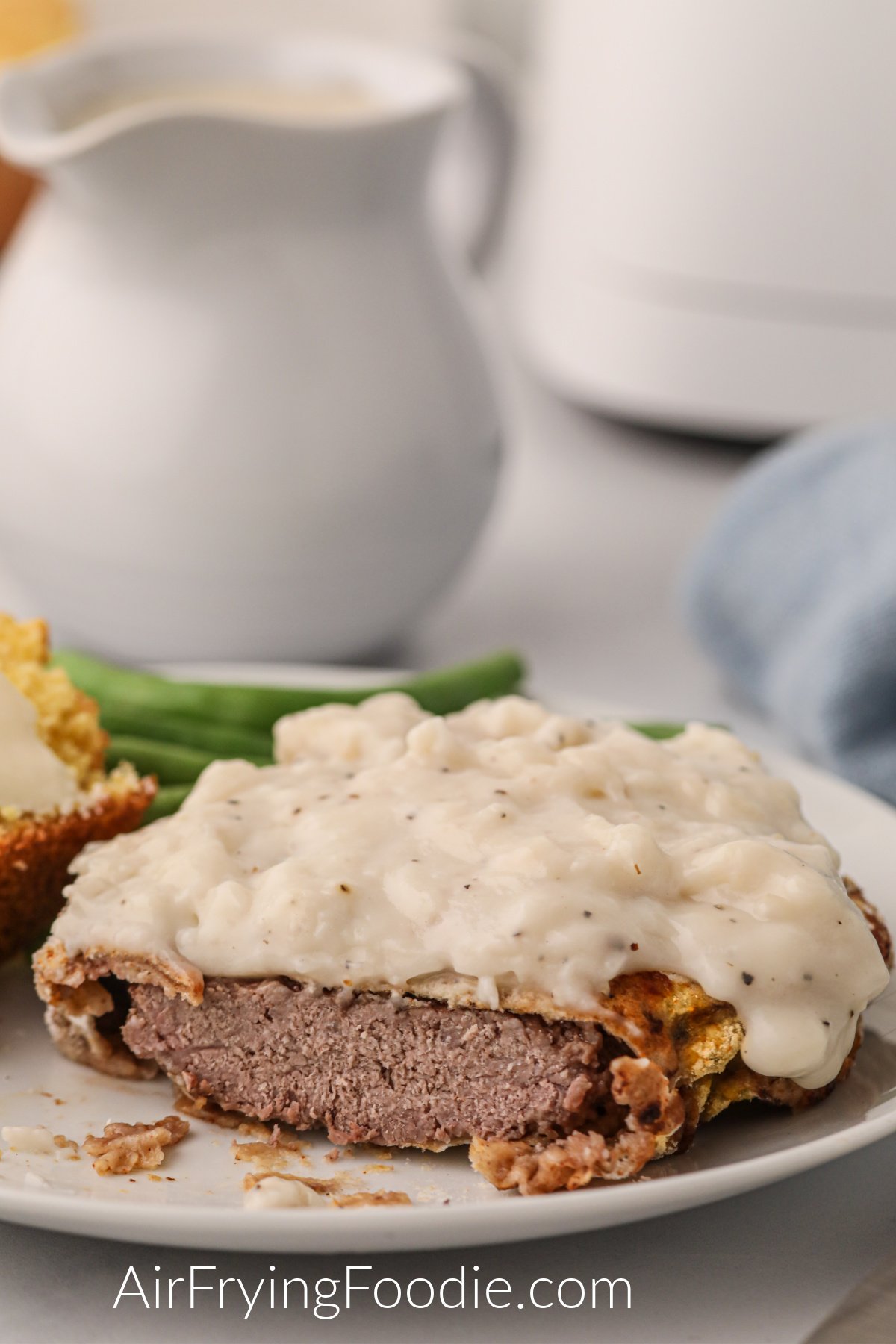 Delicious air fryer chicken fried steak covered with white gravy and ready to eat. 